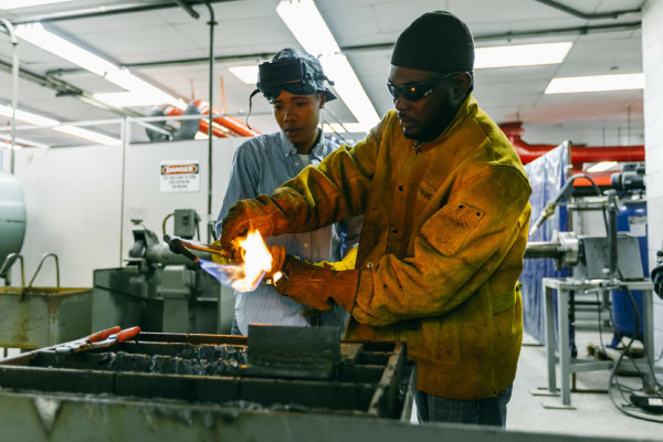 Welding student using a welding machine